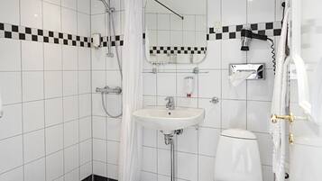 Um banheiro moderno com piso xadrez, pia branca, vaso sanitário e área de chuveiro.