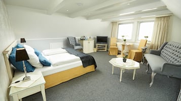 Een hotelkamer met een bed, een bank, een televisie, een tafeltje en een stoel.