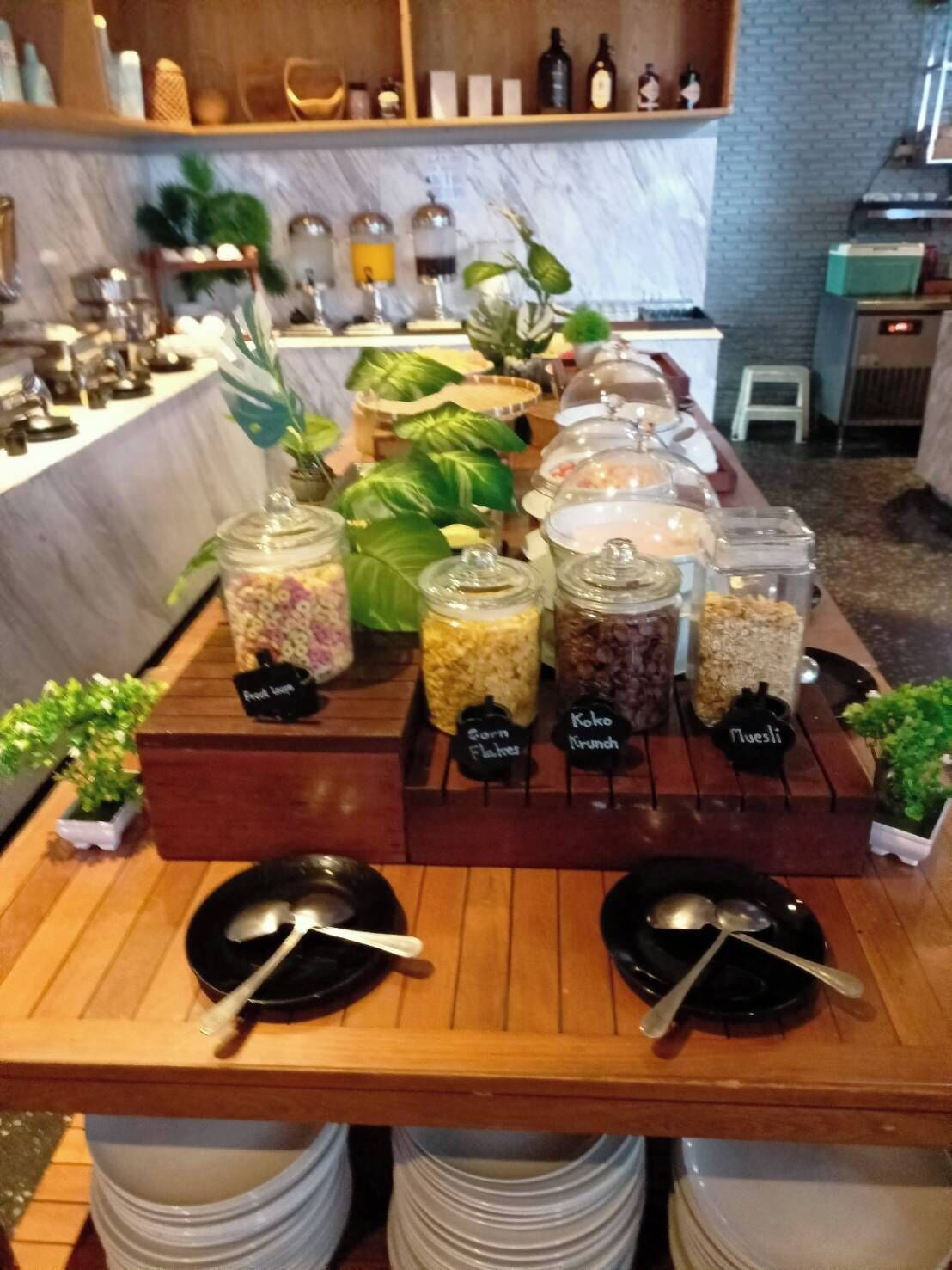 Una mesa de madera con recipientes etiquetados para un servicio de buffet.