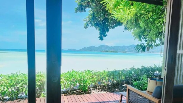A wooden deck with a view of a beach and mountains. - Casa De Mar (Koh Samui)