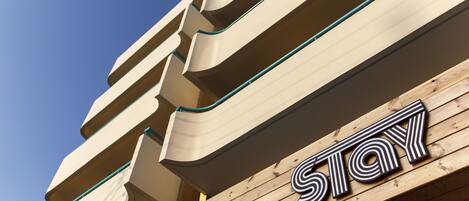 A hotel sign with the word "STAY" in stylized letters on a wooden facade.