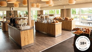 Un café moderno con mostradores de madera, una barra de café y una variedad de productos de panadería.