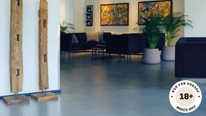 Un vestíbulo moderno con arte abstracto, zona de recepción y asientos.