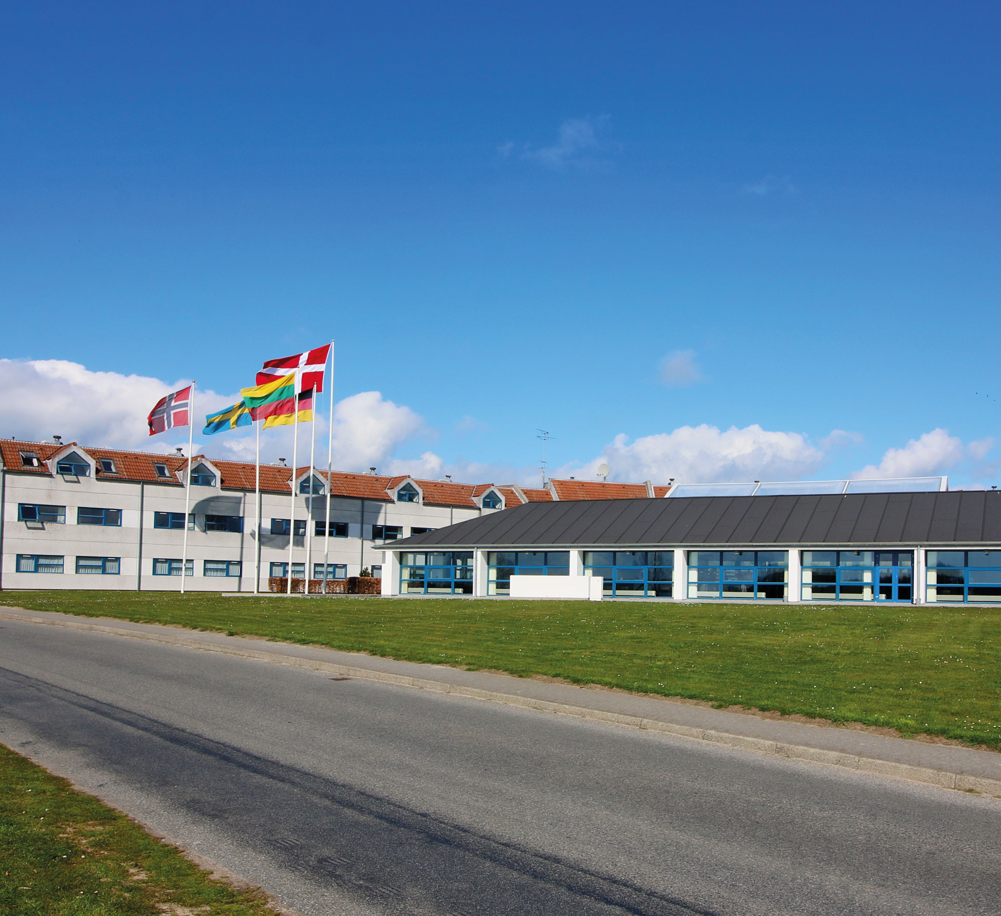 Een gebouw met diverse vlaggen, waaronder de Noorse vlag, en een bordje met de tekst 'alleen volwassenen'.
