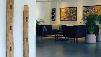 Um hall moderno com arte abstrata, uma área de recepção e assentos.