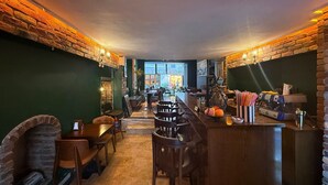 Un restaurant doté d’un bar, de murs en pierre et offrant une vue sur la rue.
