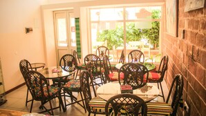 A dining area with a round table and chairs, a door, and a view of the outdoors.