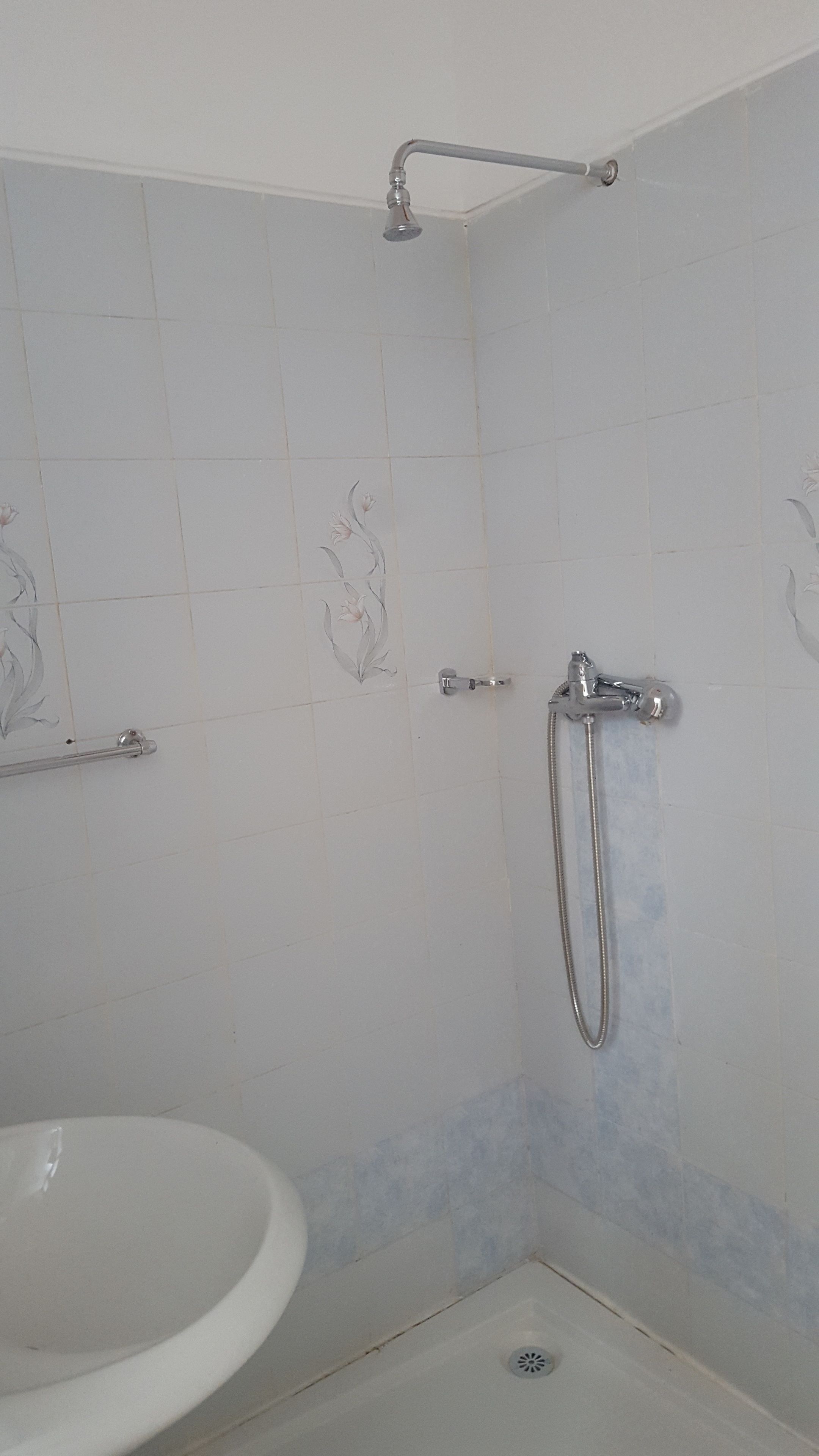 A bathroom with a shower, a toilet, and a sink.