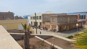 Vista urbana con edificios, una palmera y una zona comercial.