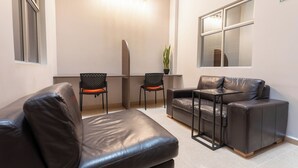 Una sala moderna con un sofá, dos sillones, una mesita y una planta en maceta.