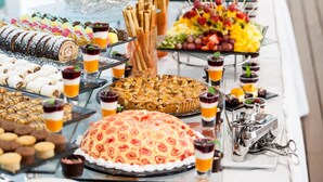 Una mesa de buffet con diferentes platillos y un arreglo floral en el centro.