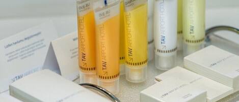 A display of TAV Airport Hotel products, including shampoo and body wash bottles, arranged on a table with white boxes.