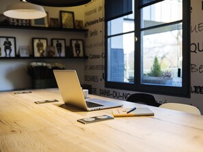 Una mesa de madera con una computadora portátil, un teléfono inteligente, un cuaderno y un bolígrafo.