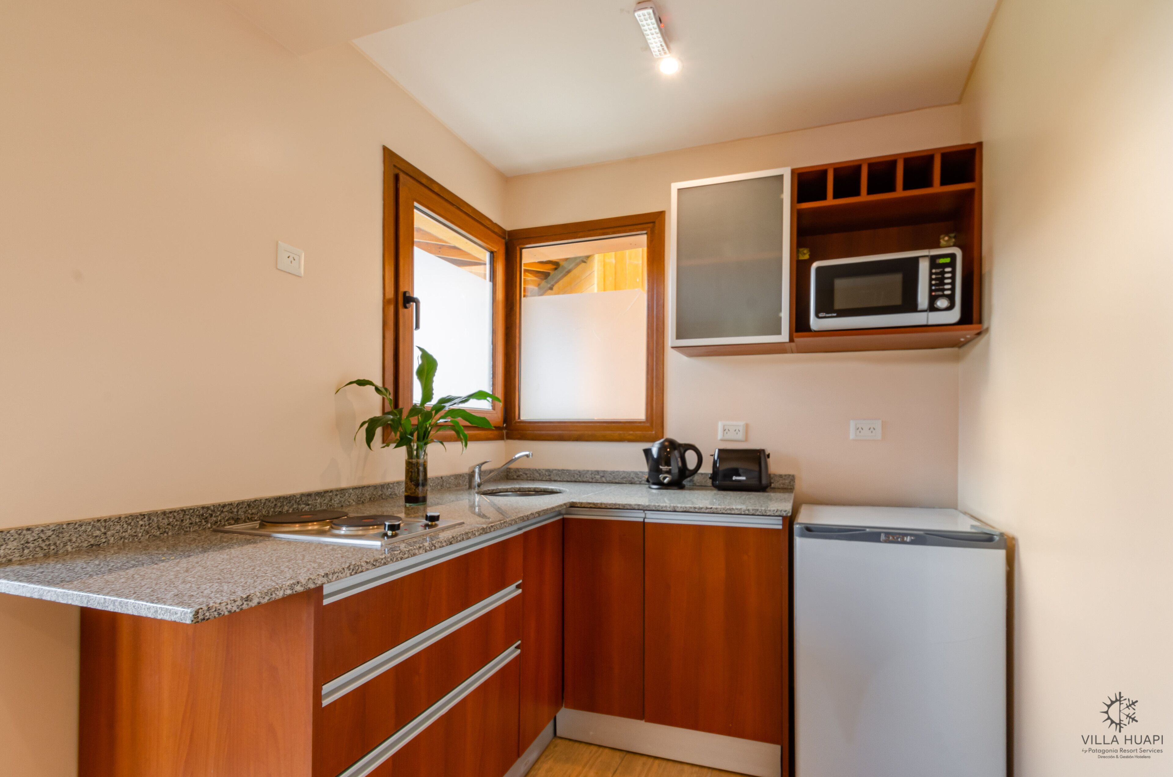 A compact kitchen with a built-in microwave, a coffee maker, and a dishwasher.