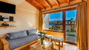A modern living room with a sofa, a coffee table, and a TV mounted on the wall. - Villa Huapi (Dina Huapi)