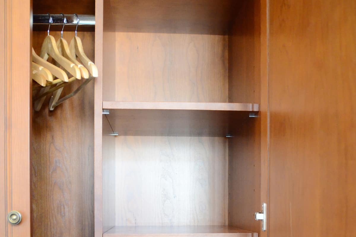 Ein Holzschrank mit mehreren Einlegeböden und Kleiderstange.