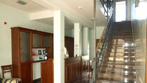 A spacious lobby with a marble staircase, wooden furniture, and a reception desk. - Villa Armin (Rovinj)