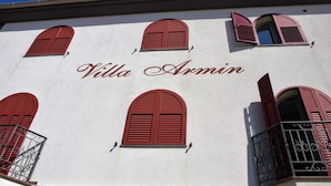 A building with the name "Villa Armin" on its facade, featuring red shutters on the windows and balconies. - Villa Armin (Rovinj)