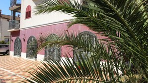 A building with a red and white facade, featuring arched windows and a balcony. - Villa Armin (Rovinj)