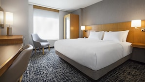 A hotel room with a large bed, a desk, a chair, and a window with curtains. - Hyatt Place New York/Yonkers (Yonkers)