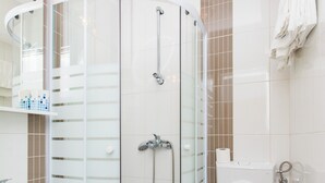 A modern bathroom with a glass-enclosed shower, a white sink, and a toilet. - Nina Apartments (Konavle)