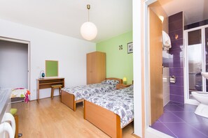 A bedroom with two single beds, a desk, and a wardrobe.
