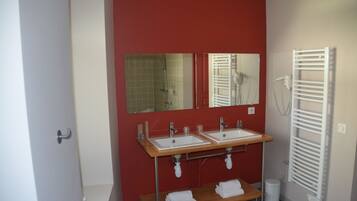 A bathroom with two sinks, a mirror, a towel rack, and a white towel shelf.