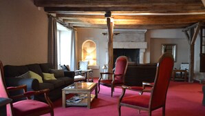 Ein gemütliches Wohnzimmer mit rotem Teppich, Holzmöbeln und einem Kamin.