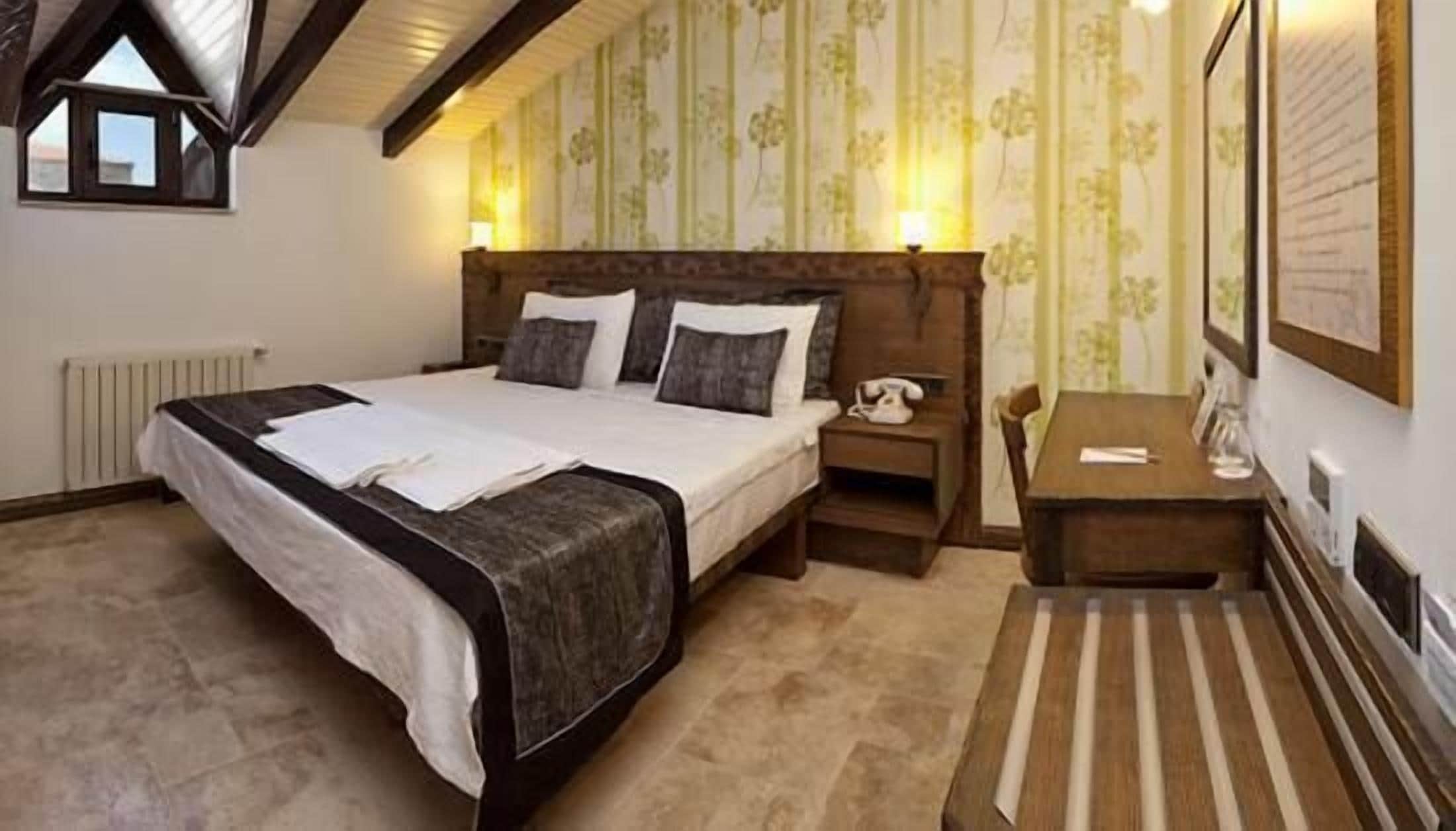 Ein Schlafzimmer mit einem großen Bett, einem Nachttisch, einem kleinen Tisch und einer Heizung.