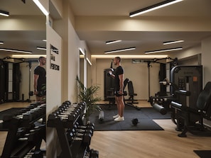 A gym with exercise equipment, mirrors, and a plant. - Cactus Hotel (Zakynthos)