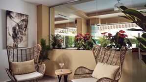 A balcony with wicker chairs, a small round table, and a martini glass. - Cactus Hotel (Zakynthos)