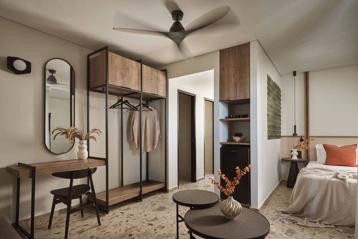 Un dormitorio moderno con cama, escritorio y armario.
