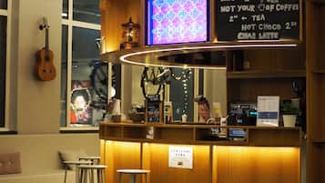 A cafe with a neon sign, a guitar, and a menu board.