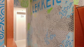 Een gang met een muurschildering met abstracte patronen en de tekst