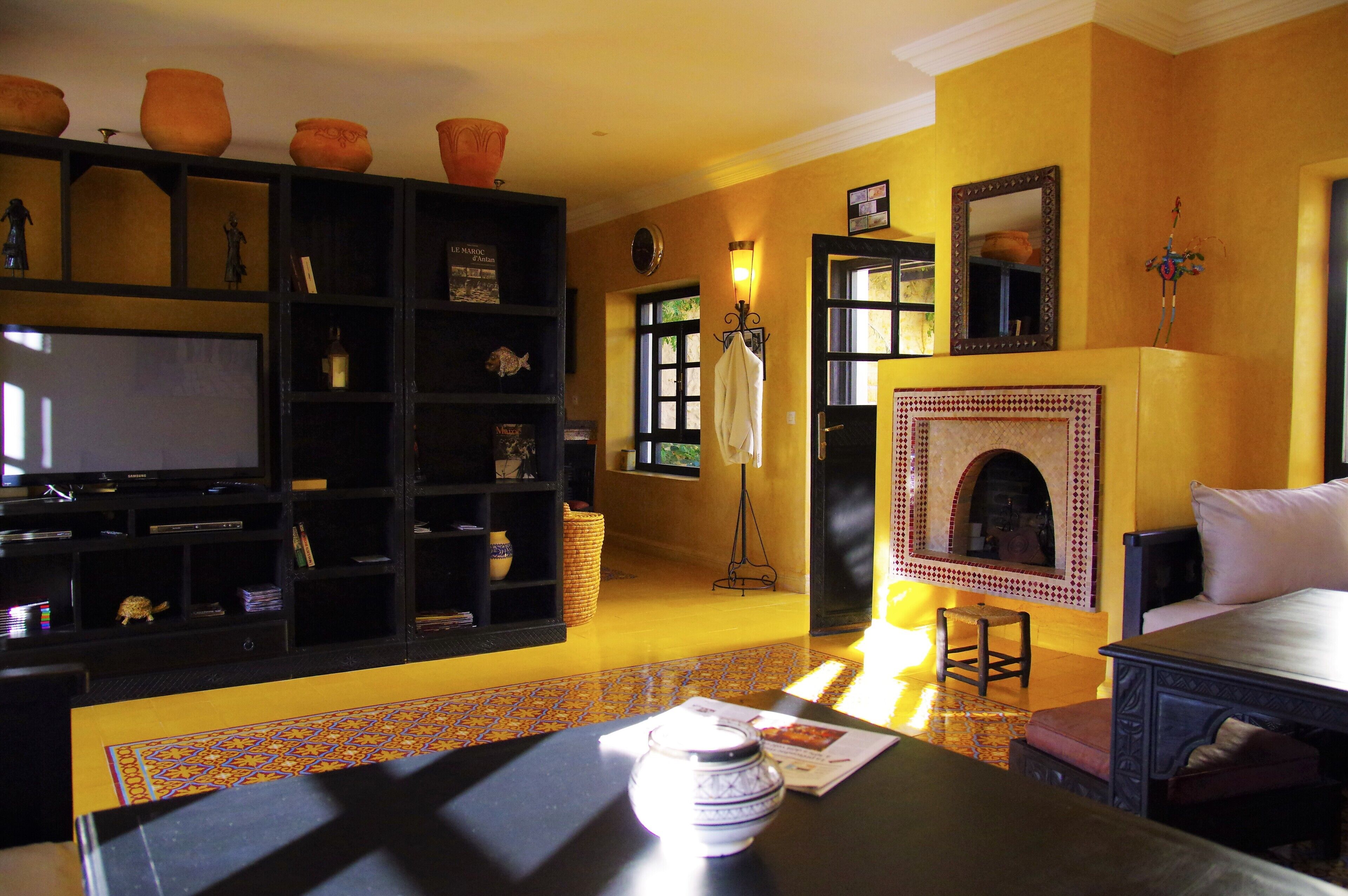 A living room with a fireplace, a television, and a bookshelf.
