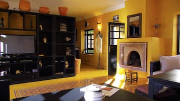 A living room with a fireplace, a television, and a bookshelf.
