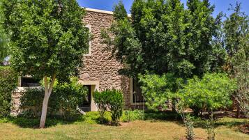 A stone building with a well-maintained lawn and trees.