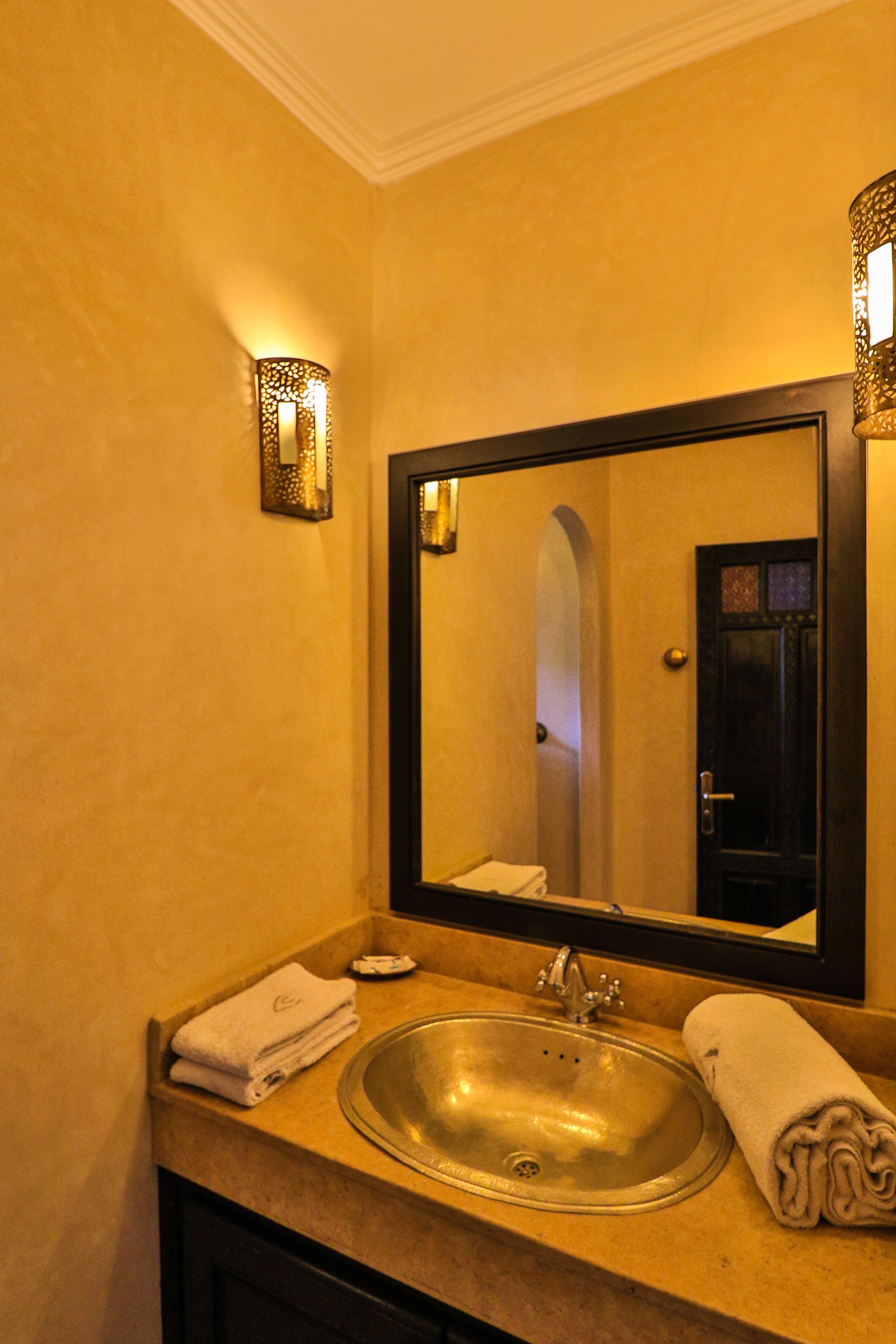 Une salle de bain équipée d’un lavabo, d’un miroir et d’un porte-serviettes.