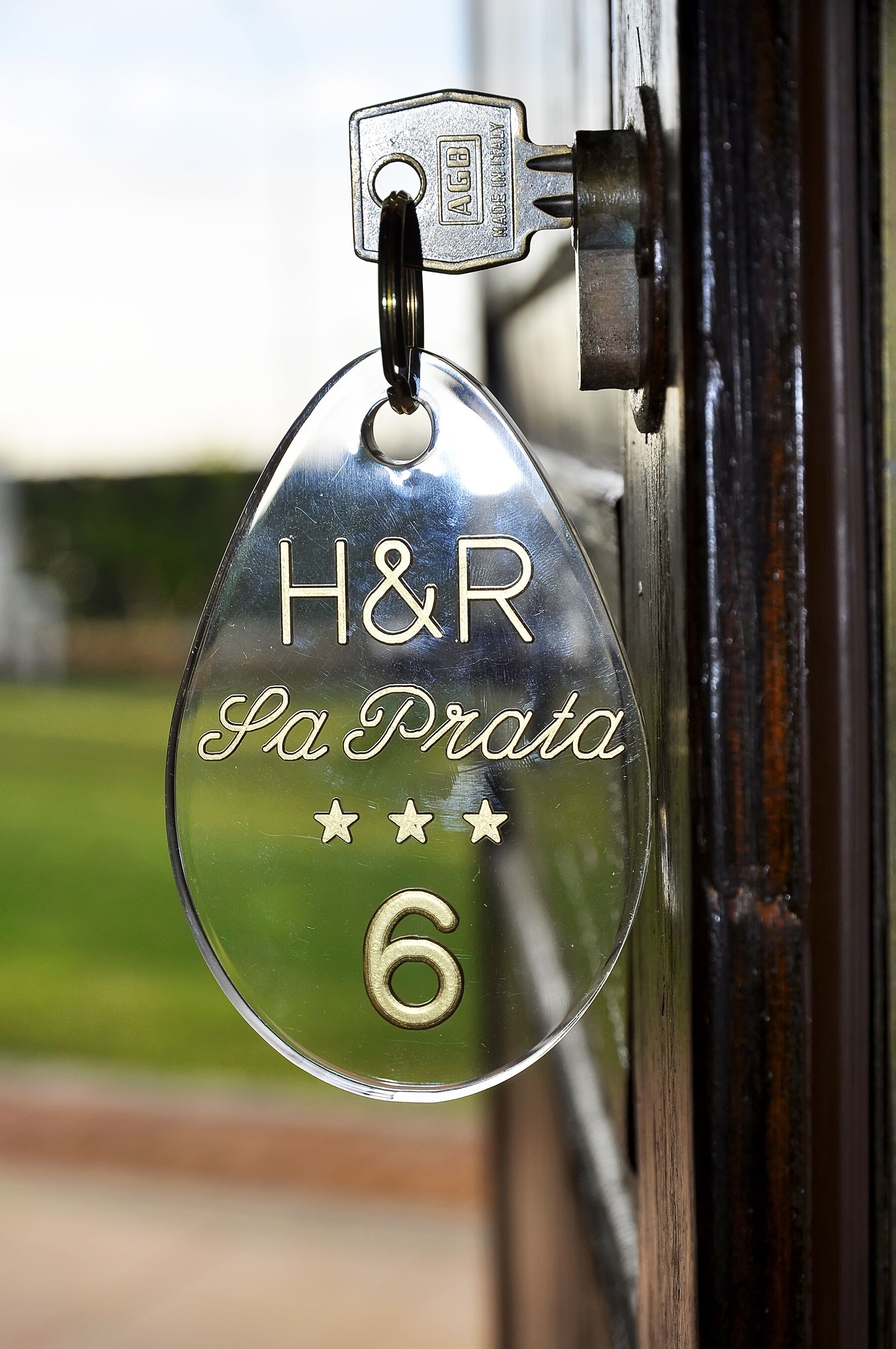 Un portachiavi metallico a forma di stella con la scritta "H&R Sa Prata" e il numero 6 inciso.