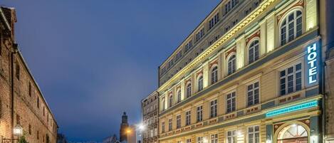 A hotel with a classic facade, large windows, and a prominent 'HOTEL' sign.