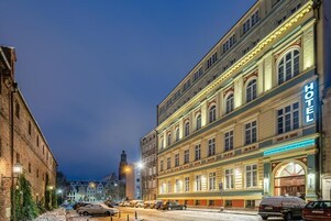 Un hotel con fachada clásica, ventanas amplias y un llamativo letrero que dice 'HOTEL'.