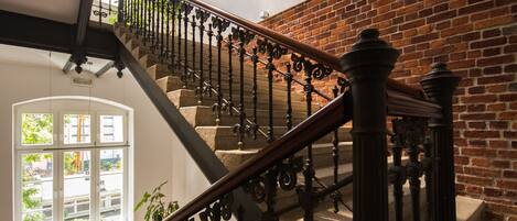 A staircase with wrought iron railings and a brick wall.