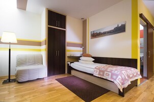 Un dormitorio con cama, una silla, un escritorio y un armario.