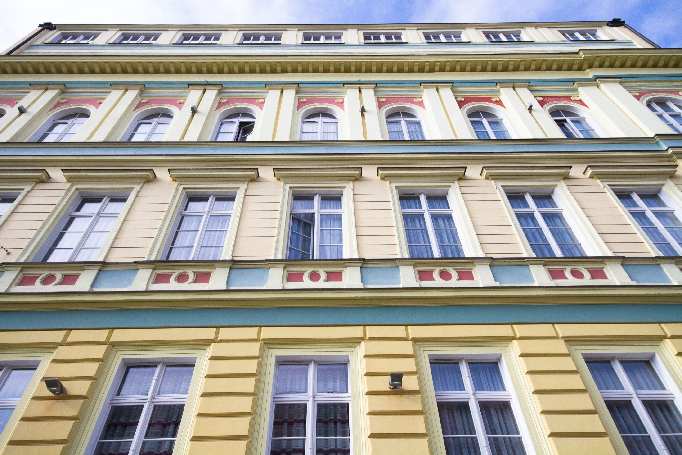A multi-story building with a classical architectural style, featuring symmetrical windows and decorative moldings.