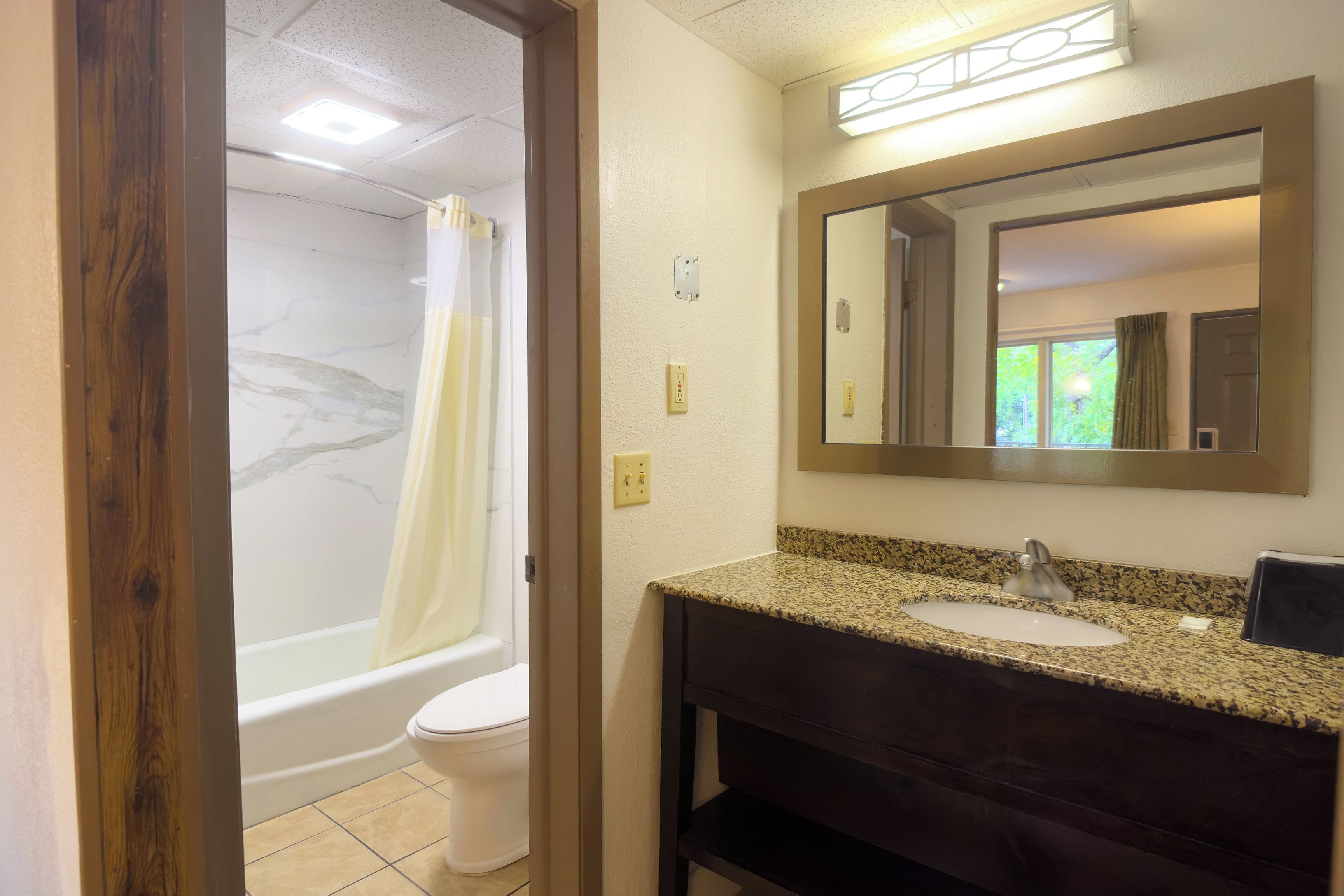 Une salle de bain équipée d’une baignoire, de toilettes et d’un meuble-lavabo avec un évier et un miroir.
