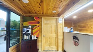 A wooden interior with a reception desk, a coffee machine, and a door.