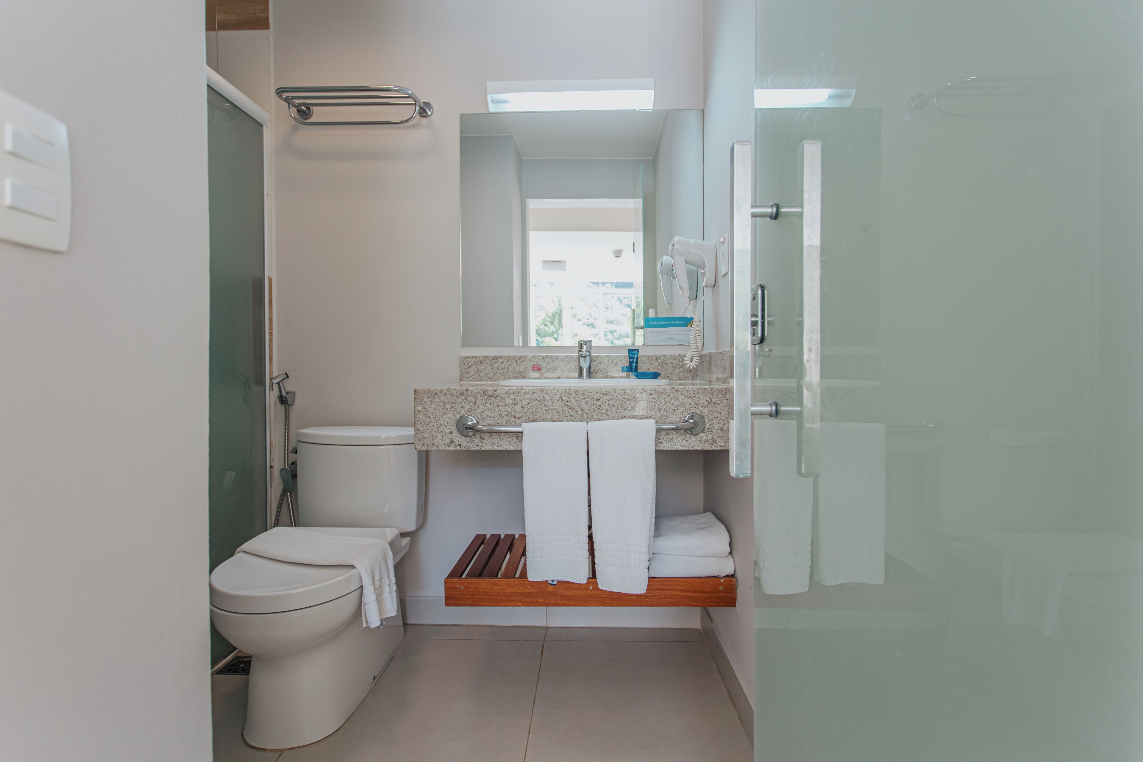 A modern bathroom with a toilet, sink, and shower.