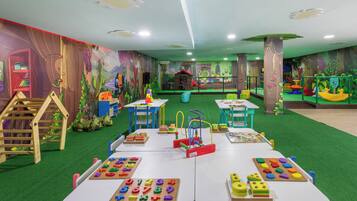 A children's play area with tables, chairs, and educational toys.
