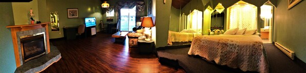 A room with a fireplace, a television, a bed with a canopy, and a window with curtains. - Hotel Motel Bonsoir (Granby)