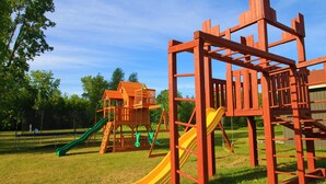 Un parque infantil con un tobogán amarillo y una estructura para escalar.